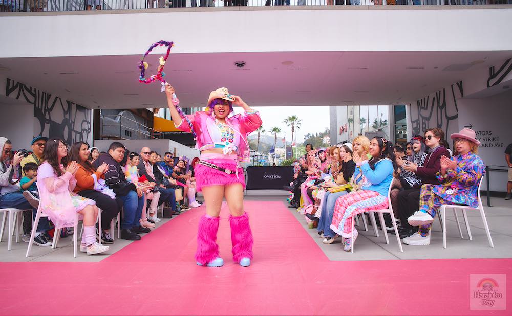 A fashion model in mostly pink outfit with a cowboy hat twirls a pink lasso during Kawaii Fashion Show