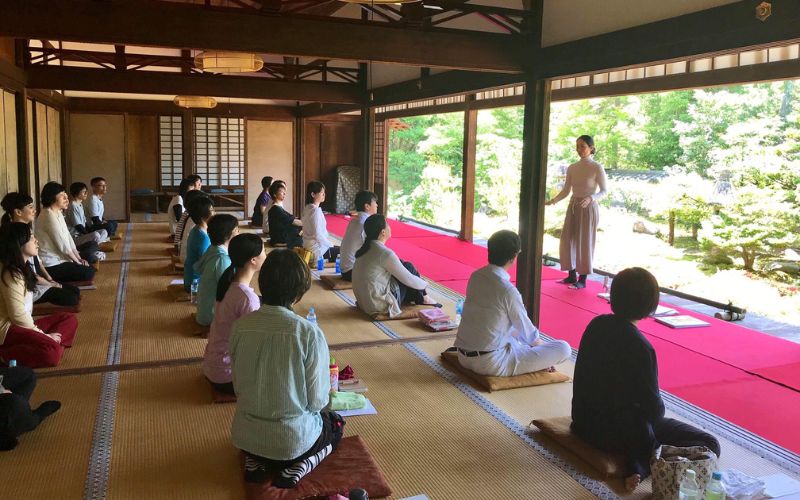 Instructor Yuki Shiina teaching Zen Kokyū to a group of students, all sitting on the floor with tatami