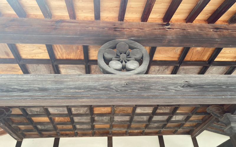 A “kamon” (family crest) displayed on a wooden beam.