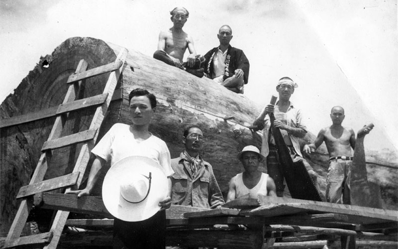 A black and white photo of Japanese woodworkers