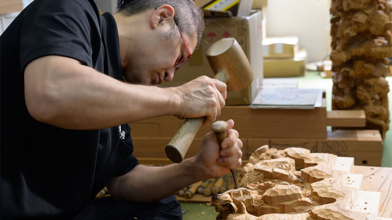 Akihiko Maeda working on wooden carvings