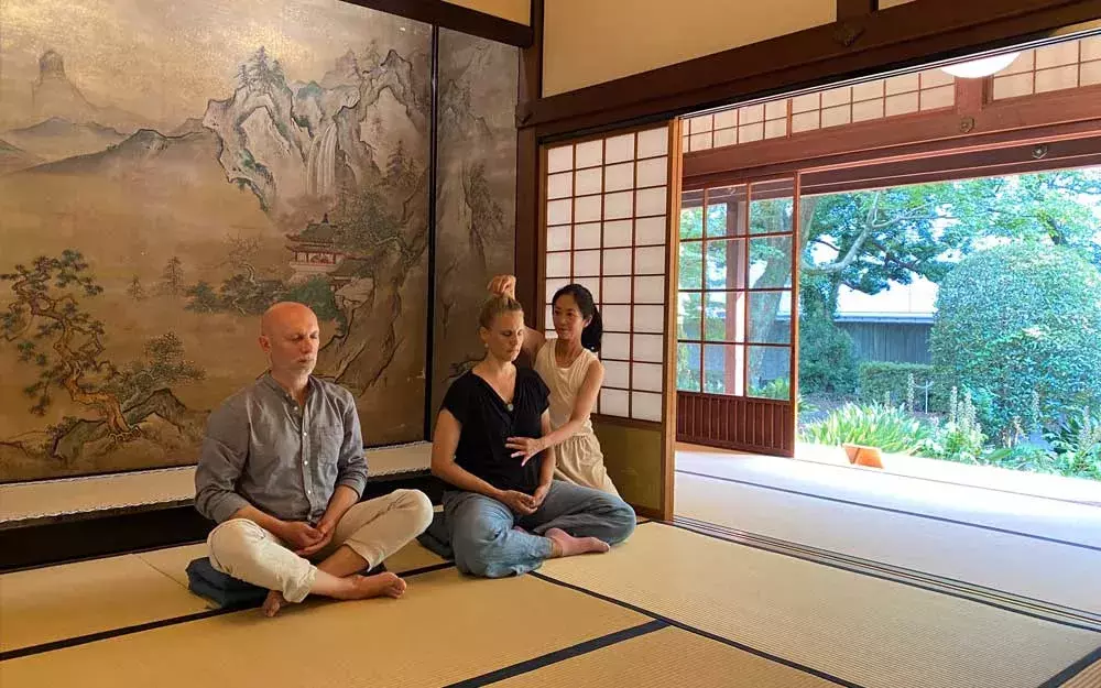 Instructor Yuki Shiina teaching Zen Kokyū to two students, sitting on tatami 