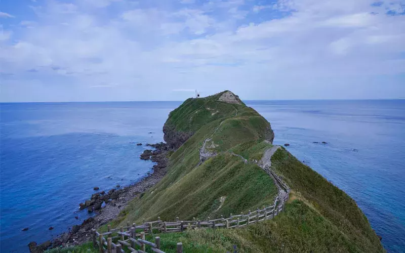 Scenic view of Hokkaido's Kamui Misaki Cape, featuring rugged cliffs and the vast ocean.