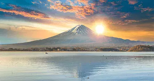 First sunrise of the year (Hatsuhinode) over the mountains, with a reflective water body below.